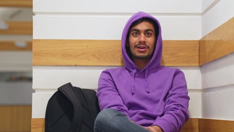 Sri-Lankan-man-wearing-vibrant-purple-hoodie-having-conversation-behind-camera