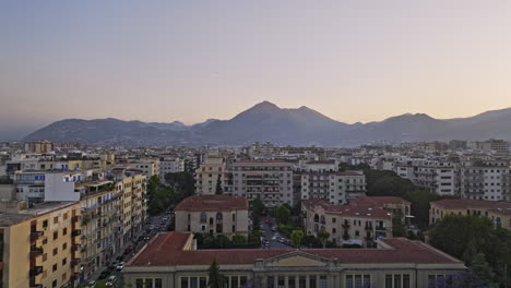 Sobrevuelo-Aéreo-V1-De-Palermo-Italia-A-Través-De-Isonzo-Que-Captura-El-Paisaje-Urbano-De-Los-Barrios-Urbanos-Al-Atardecer-Con-Montañas-En-El-Horizonte-Y-Pájaros-Volando-A-Través-De-La-Escena---Filmado-Con-Mavic-3-Cine---Mayo-De-2023