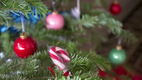 Detailed-Christmas-pine-tree-branches-adorned-with-numerous-Christmas-colorful-balls-ornaments-and-candies-during-the-winter-season