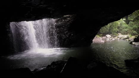 View-of-waterfall-and-Cave-Creek-from-inside-the-cave-at-Natural-Arch,-Natural-Bridge,-Springbrook-National-Park
