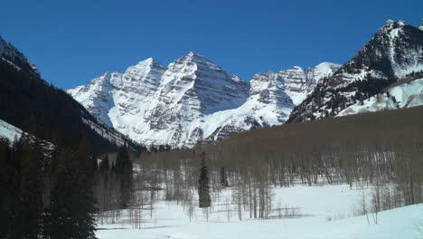 Maroon-Bells-14er-Aspen-Snowmass-spring-winter-avalanche-ranch-snowmobile-trail-Rocky-Mountains-Colorado-Capital-peakincredible-sunny-blue-sky-scenic-landscape-Crested-Butte-pan-slowly-left-zoomed