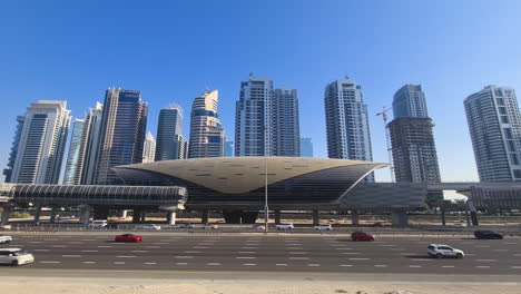 Dubai,-Emiratos-Árabes-Unidos,-La-Estación-De-Metro-Sobha-Realty,-Rascacielos-Y-Tráfico-En-Sheikh-Zayed-Road.