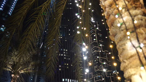 Dubai,-Emiratos-Árabes-Unidos,-Decoración-De-Luces-De-Navidad-Y-Año-Nuevo-Alrededor-De-Una-Palmera-Por-La-Noche-En-El-Puerto-Deportivo
