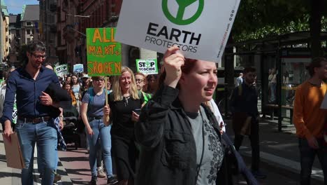Earth-Protectors-sign-at-climate-protest-rally,-girl-with-megaphone