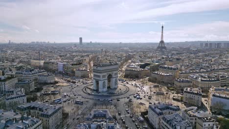 Triumphal-arch-or-Arc-de-Triomphe-with-Tour-Eiffel-and-Montparnasse-tower-in-background,-Paris-cityscape,-France