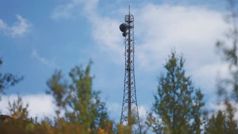 A-communication-tower-with-antennae-stands-above-the-autumn-forest