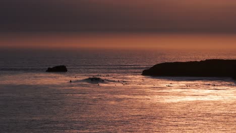 Drohnen-Luftaufnahme-Von-Perfekten-Wellen-Bei-Sonnenuntergang-Und-Surfern-Im-Wasser,-Die-Warten