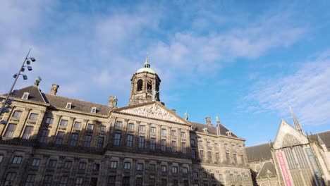 Panoramic-tilt-up-wide-shot-of-the-historic-Royal-Palace-of-Amsterdam,-Netherlands-during-daytime