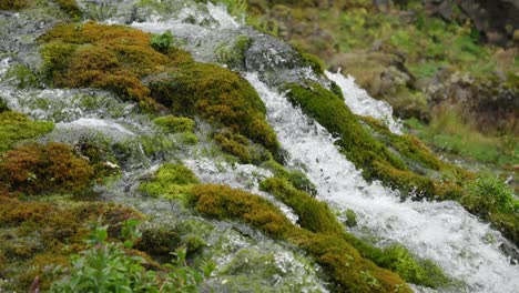 Panning-close-up-of-beautiful-streams-of-small-waterfalls-run-into-a-crystal-clear-and-clean-river