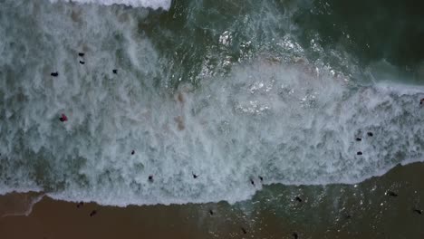 drone-with-camera-pointing-down-and-filming-waves-and-foam-in-the-sea-at-Ipanema-beach,-Brazil