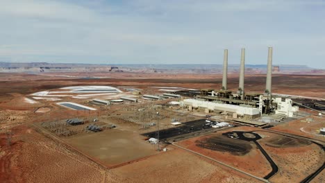 A-drone-shot-of-the-“Navajo-Generating-Station”,-a-massive-coal-fired-power-plant-and-industrial-complex-with-tall-stacks,-in-the-middle-of-the-desert-of-the-Navajo-Nation,-located-near-Page,-Arizona