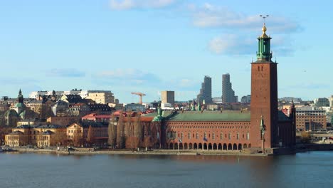 Wide-static-view-of-Stockholm-City-Hall-by-still-water-on-sunny-day