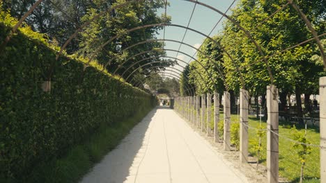 Gärten-Von-Schloss-Mirabell-In-Salzburg,-Mit-Statuen,-Gepflegten-Hecken-Und-Touristen,-Die-An-Einem-Sonnigen-Tag-Die-Landschaft-Genießen