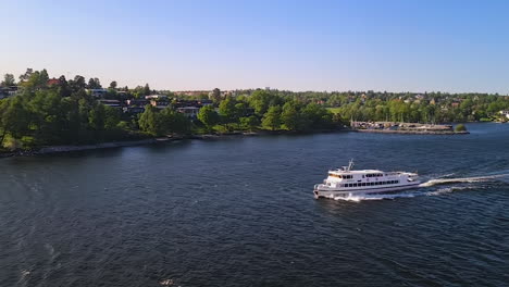 Ferry-Boat-Moving-in-Fjord-Under-Upscale-Residential-Neighborhood-of-Stockholm,-Sweden