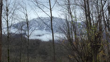 Niedrige-Wolken-An-Einem-Trüben-Tag-In-Der-Bergwelt,-Der-Gipfel-Im-Hintergrund-Der-Malerischen-Winterlandschaft-Im-Hyrkanischen-Wald-Im-Ländlichen-Dorf-Im-Iran,-Baumzweige-Blühen-Im-Frühling