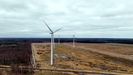 Tres-Turbinas-Eólicas-Están-A-Lo-Lejos,-Con-Un-Cielo-Nublado-Al-Fondo