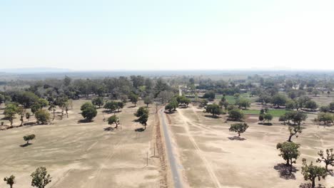 Aerial-shot-of-barren-arid-land-with-asphalt-road-in-Charu-village-in-Chatra,-Jharkhand,-India
