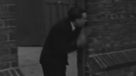 Man-Peeking-through-a-Brick-Building-Door-in-the-City-in-1930s