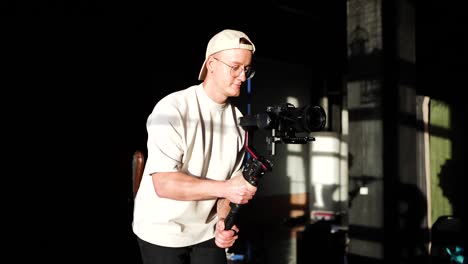 Videographer-with-gimbal-stabilizer-camera-equipment-walk-smoothly-in-studio