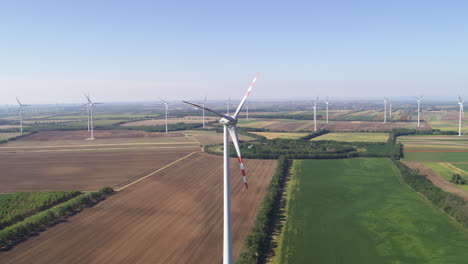 Grand-vista-aerial-of-renewable-energy-wind-farm-turbines-amongst-farm-land-and-crop-fields