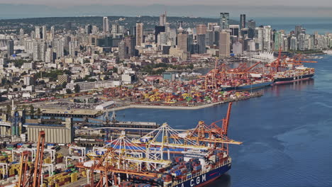 Vancouver-BC-Canada-Aerial-v92-drone-flyover-the-harbour-capturing-bustling-container-terminal,-a-crucial-shipping-hub-with-downtown-cityscape-on-the-skyline---Shot-with-Mavic-3-Pro-Cine---July-2023