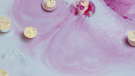 Close-up-of-colorful-ink-dissolving-in-water-with-circular-objects