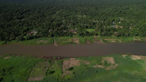 Tilt-up-drone-shot-of-village-on-the-dense-jungle,-Amazon,-Colombia