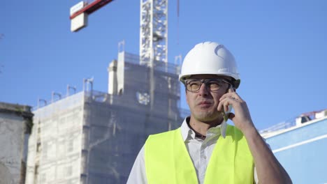 Auf-Der-Baustelle-Löst-Ein-Junger-Ingenieur-Mit-Brille-Und-Weißem-Helm-Probleme-Am-Telefon