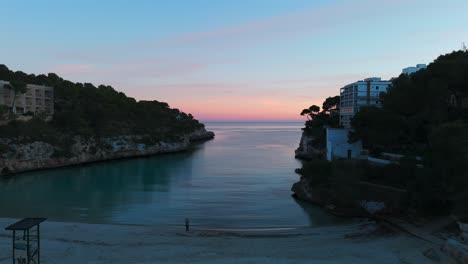 Luftaufnahme-Des-Ruhigen-Buchtwassers-Mit-Rosa-Sonnenuntergangswolken-Am-Horizont-In-Palma-De-Mallorca