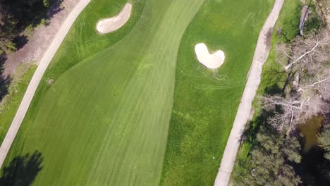 4K-Panning-Birds-Eye-View-of-A-Fairway-and-Green-on-a-Golf-Course-in-Los,-Angeles,-California-on-a-Warm-Sunny-Day-With-Breathtaking-Views