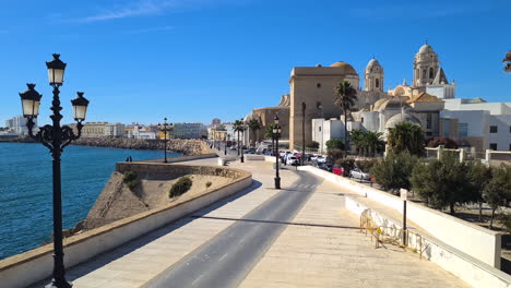 Cadiz,-Spain,-Promenade,-Traffic-by-Atlantic-Ocean-and-Cathedral-on-Hot-Summer-Day