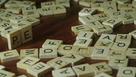 Male-right-hand-forms-country-word-PERU-from-assorted-Scrabble-tiles