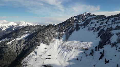Densa-Nieve-Cubre-Las-Laderas-De-Las-Montañas-Y-Crestas-Con-Bosques-De-Pinos-En-El-Día-Del-Cielo-Azul