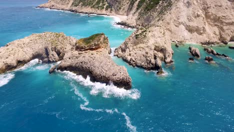 Toma-De-Drones-En-órbita-De-Las-Rocas-En-La-Costa-Rocosa-De-La-Playa-De-Petanoi,-Ubicada-En-La-Isla-De-Cefalonia-En-Grecia.