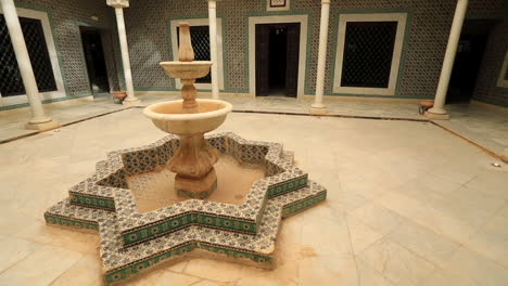 Wide-angle-shot-of-an-Arabic-styled-courtyard-with-a-fountain-in-Sbeitla,-Tunisia