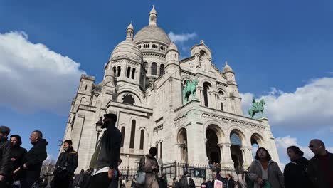 Crowd-of-people-at-Sacre-Coeur-with-clouds-moving-in-blue-sky,-Montmartre-in-Paris,-France