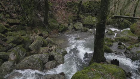 Rushing-river-over-mossy-rocks-in-Barrias,-Felgueiras-Portugal---aerial
