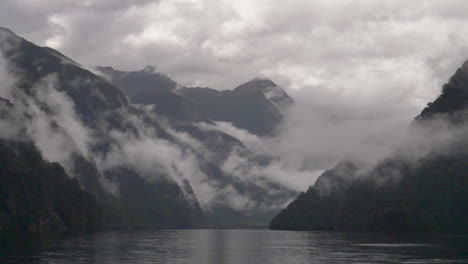 Zeitlupen-Schwenk-über-Neblig-wolkige-Berge-Im-Doubtful-Sound-Mit-Wasser-Im-Vordergrund---Patea,-Neuseeland