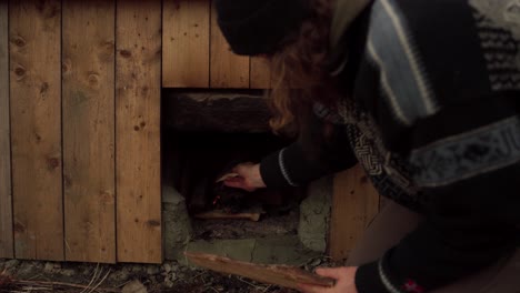 Man-Putting-Firewood-To-Heat-His-DIY-Hot-Tub---Close-Up