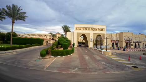 Driving-by-Sea-Beach-Aqua-Park-in-Egypt,-Palm-Trees-Sharm-El-Sheikh