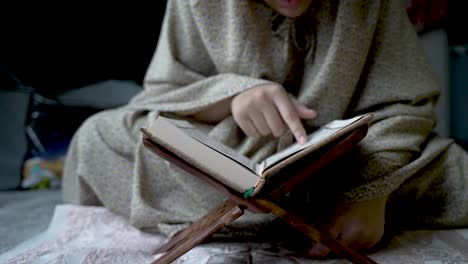 Cropped-Portrait-Of-Muslim-Woman-Pointing-Finger-On-Religious-Text-While-Reading-Quran