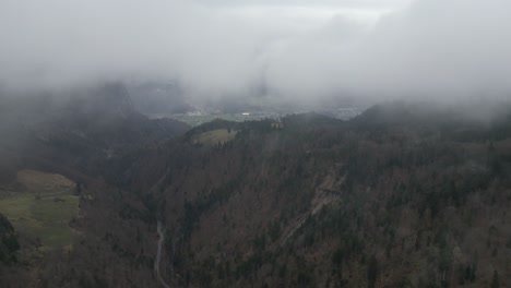 Fliegen-Sie-Durch-Neblige,-Tief-Hängende-Wolken-In-Malerischen-Europäischen-Bergen-über-Dem-Blattlosen-Walddach-Im-Tal