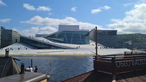 Oslo-Opera-House-Building,-Norway,-Landmark-and-Saunas-on-Bjorvika-Neighborhood-Waterfront-on-Sunny-Day