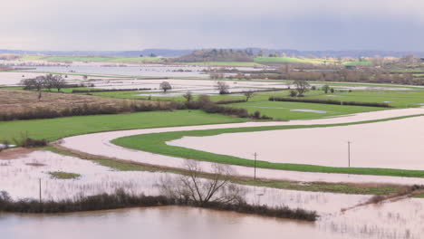 Flooded-Somerset-countryside-farmland-after-severe-rainfall,-aerial-dolly
