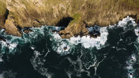 Top-down-view-slowly-pulling-away-from-rugged-Oregon-Coast-along-Pacific-Ocean