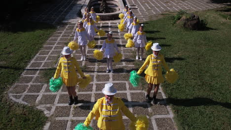 Aerial-View,-Majorette-Girls-in-Yellow-and-White-Uniforms-Performing-on-Festival