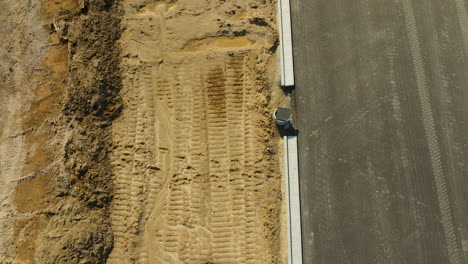 Detailed-view-of-a-road-construction-site-with-tire-tracks-on-the-soil