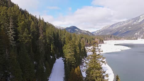 Majestic-View-with-drone-of-Lake-Kachess-with-evergreen-trees-and-snow-in-Washington-State