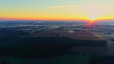 Aerial-panoramic-view-of-faded-sunset,-glow-vivid-light-over-forestry