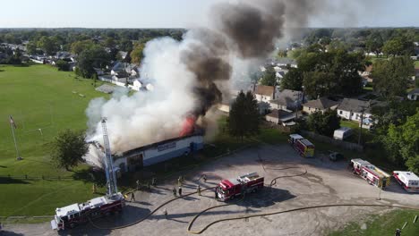 Building-fire-with-open-flame-and-massive-amount-of-smoke,-aerial-drone-view